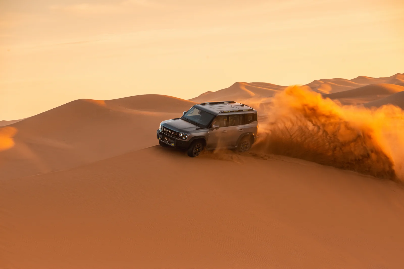 JETOUR T2 en las dunas del desierto al atardecer