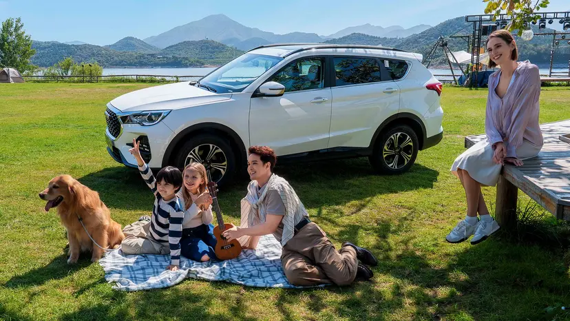 Familia con su perro disfrutando de un día de campo junto a un JETOUR X70 blanco